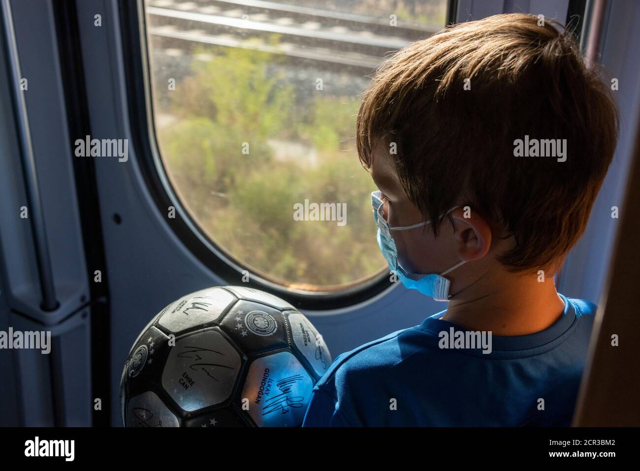 Boy trägt eine Maske, Atemschutzmaske, medizinische Maske, Mund-und Nasenschutz auf dem Zug Stockfoto