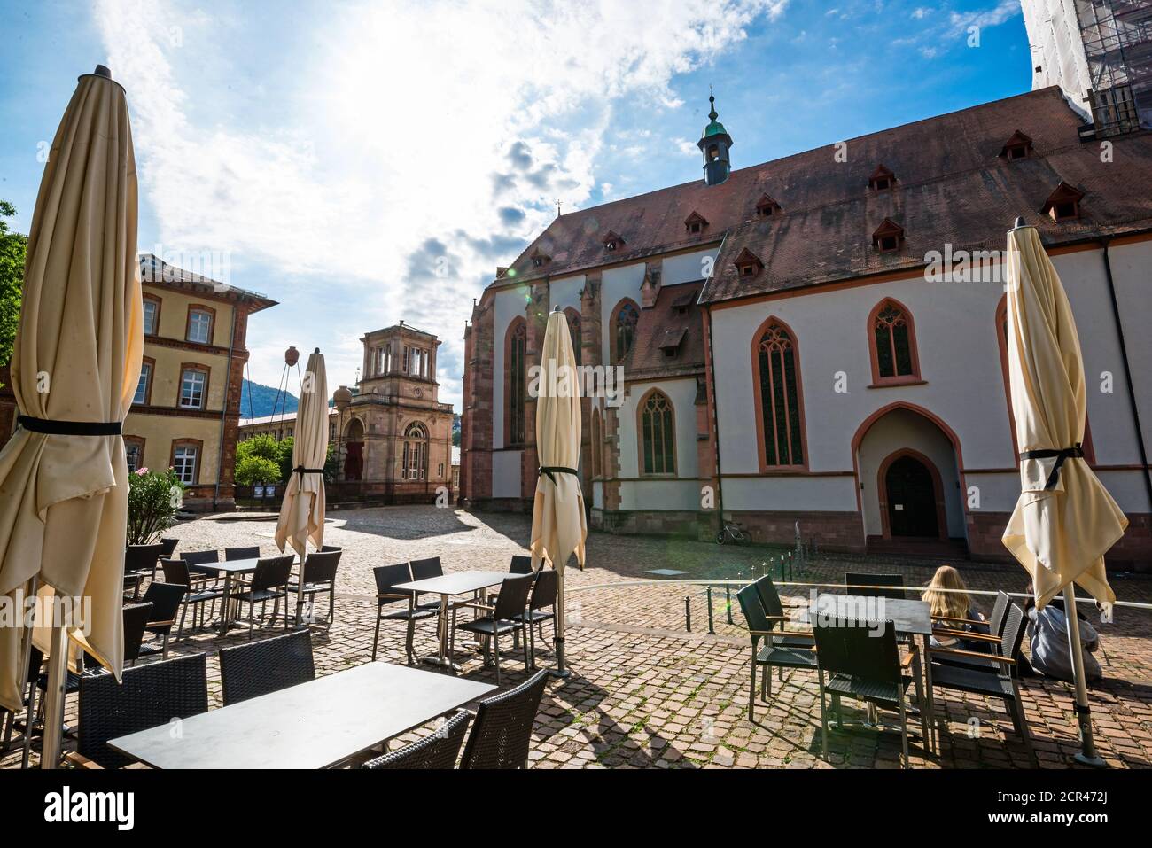 Morgens auf dem Platz vor der Stiftskirche, im Vordergrund Tische und Stühle aus einem Restaurant. Stockfoto