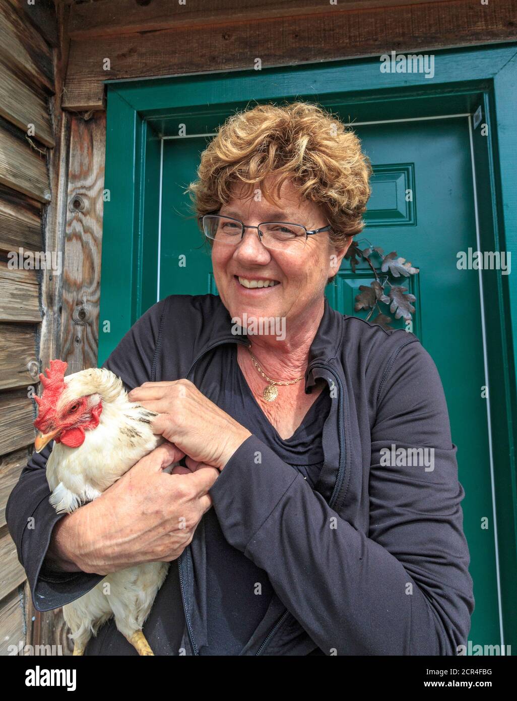 Laura Waters in ihrem Geschäft, Snowdon House, außerhalb von Victoria, BC, Kanada auf Vancouver Island, wo sie Esswaren aus Neuwachstum auf douglasien verkauft. Dazu gehören Essige, Marmeladen, getrocknete Gewürze und vieles mehr. Sie verkauft auch frische Eier von ihren Hühnern, einschließlich des in ihren Armen. Stockfoto