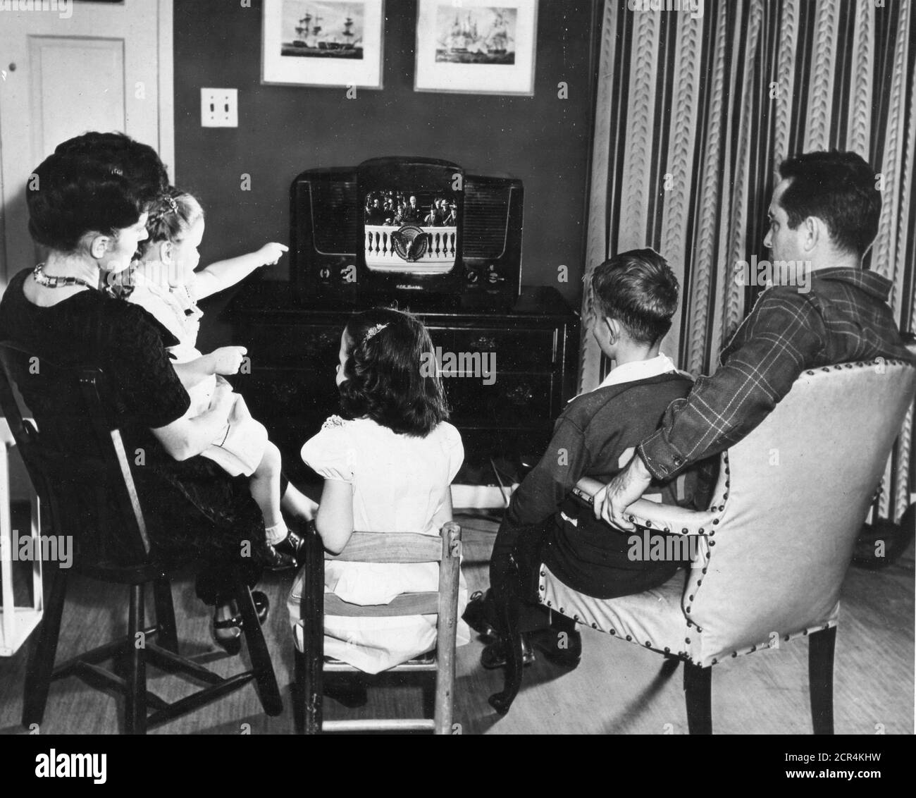 Zusammengesetztes Foto einer gut gekleideten fünfköpfigen Familie, die vor einem Fernsehtisch-Modellsatz sitzt und die Rede zur Amtseinführung des Präsidenten von Harry S. Truman 1949 auf den Stufen des Kapitols, 1949, anspricht. (Foto vom State Department/RBM Vintage Images) Stockfoto