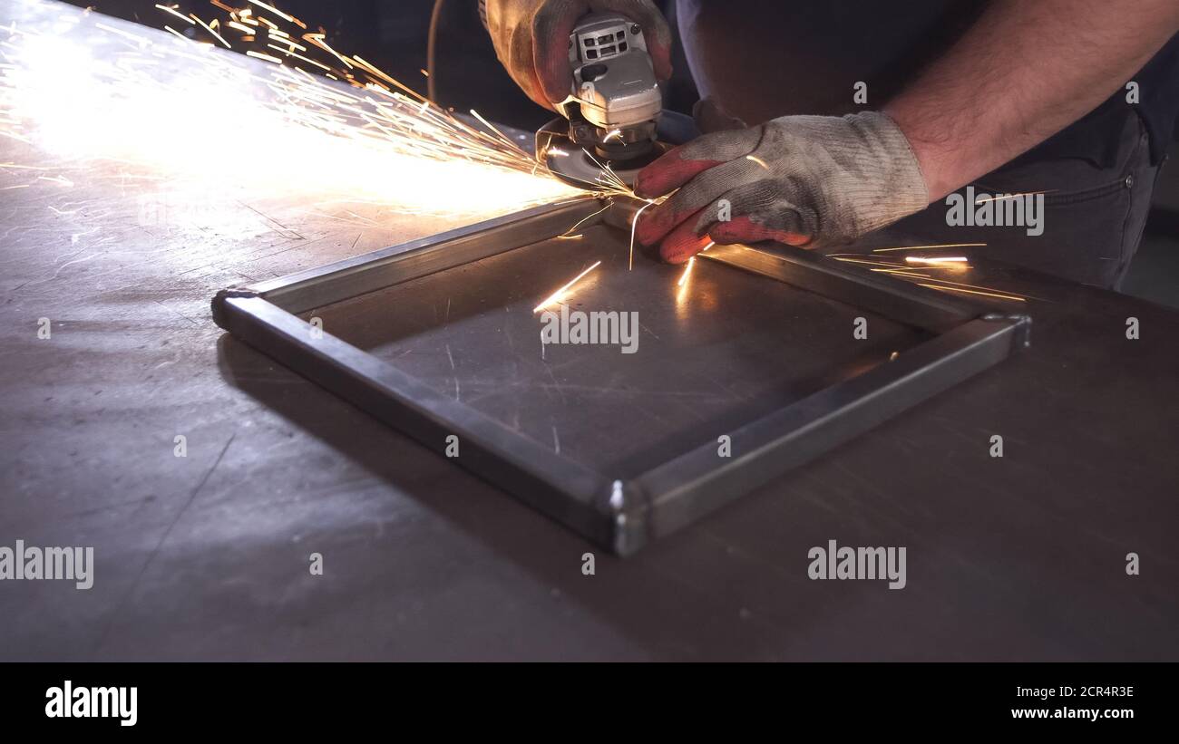 Schleifen in Stahlmanufaktur. Arbeiter mit großer Säge poliertem Metall. Stockfoto