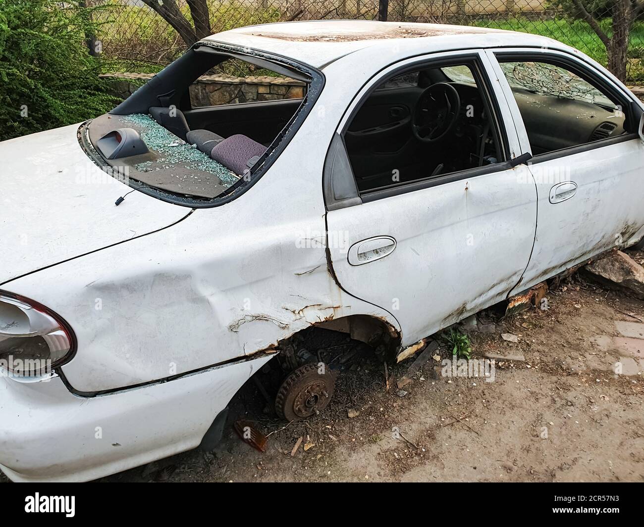 Metallschrott, zerbrochene, verlassene weiße Autos ohne Räder und Fenster Stockfoto