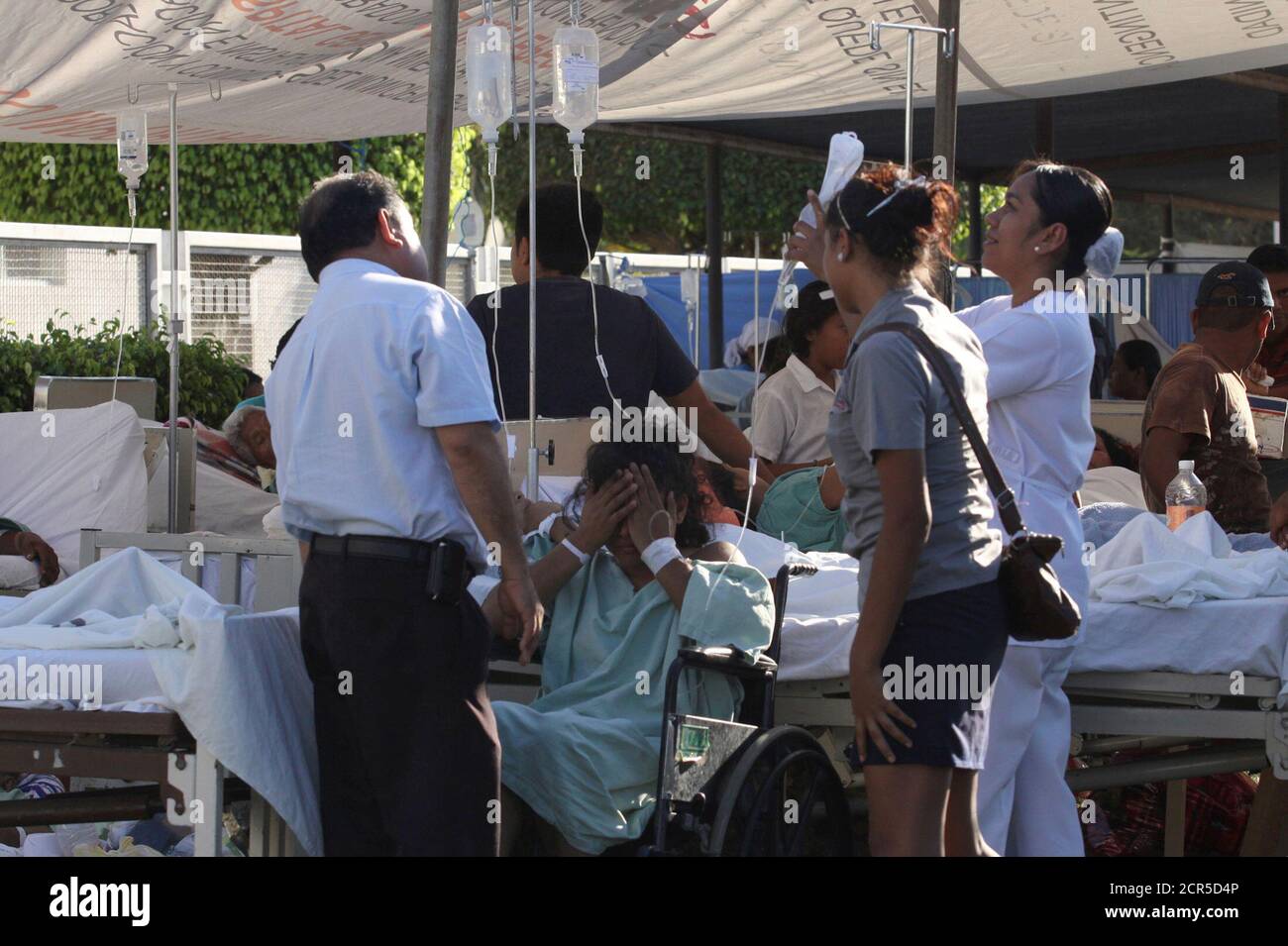 Ein Patient im Rollstuhl wird von einer Krankenschwester in einer Notaufnahme betreut, nachdem er am Dienstag in Ometepec im mexikanischen Bundesstaat Guerrero, dem 20. März 2012, aus einem Krankenhaus evakuiert wurde, das durch ein Erdbeben beschädigt wurde. Das Erdbeben der Stärke 7.4 traf am stärksten im südwestlichen Bundesstaat Guerrero, wo rund 800 Häuser beschädigt wurden, sagten Beamte. Der Gouverneur des Bundesstaates Angel Aguirre sagte, er habe Berichte über die Häuser niedergeschlagen, obwohl die staatlichen Behörden dies nicht bestätigen konnten. REUTERS/Jacob Garcia (MEXIKO - Tags: KATASTROPHE) Stockfoto
