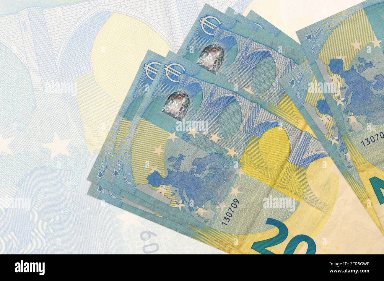 20 Euro Scheine liegen im Stapel auf dem Hintergrund der großen halbtransparenten Banknote. Abstrakte Darstellung der nationalen Währung. Geschäftskonzept Stockfoto