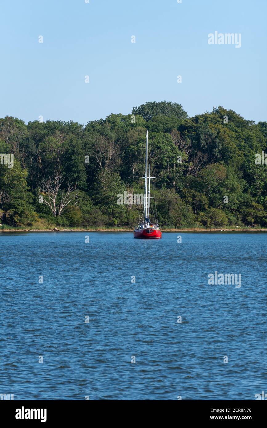 Deutschland, Mecklenburg-Vorpommern, Stralsund, rotes Segelboot liegt in einer Bucht in Strelasund, einer Einmündung der Ostsee Stockfoto