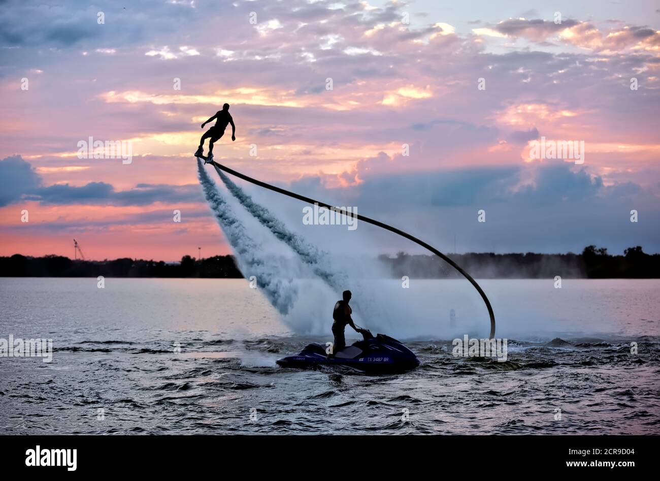 Rocket man fliegt auf einem Jet Fly Board bei Sonnenuntergang in Lake Arlington, Texas. Stockfoto