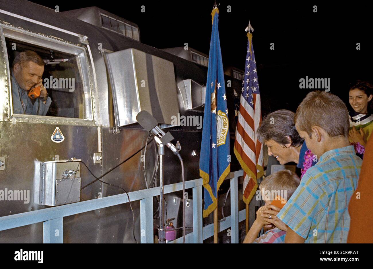 Neil A Armstrong, Kommandant der Apollo 11 Flug, begrüßt seinen Sohn Mark, Telefon, Gegensprechanlage, während seine Frau Jan und ein weiterer Sohn Eric Blick auf Stockfoto