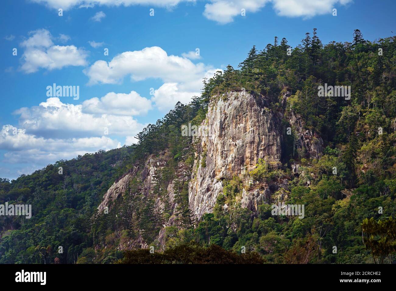 Berg von vulkanischen Kern mit Vegetation gegen eine trübe bedeckt Blauer Himmel Hintergrund Stockfoto