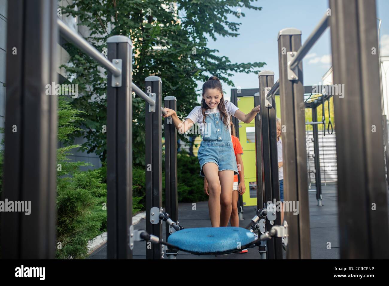 Kinder spielen zusammen in Dschungel-Fitness-Studio und fühlen sich toll Stockfoto