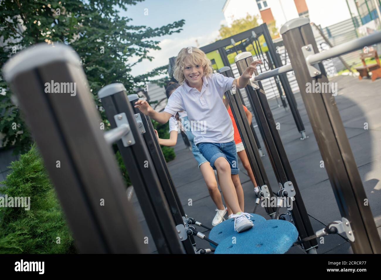 Blonde junge läuft im Dschungel Turnhalle und Gefühl aufgeregt Stockfoto