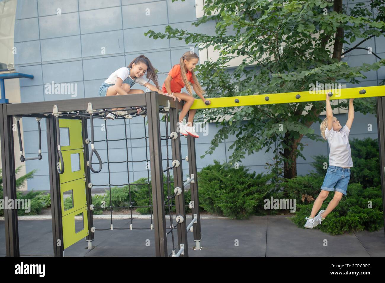 Blonde junge hängen an den Händen, während seine Freunde beobachten Stockfoto