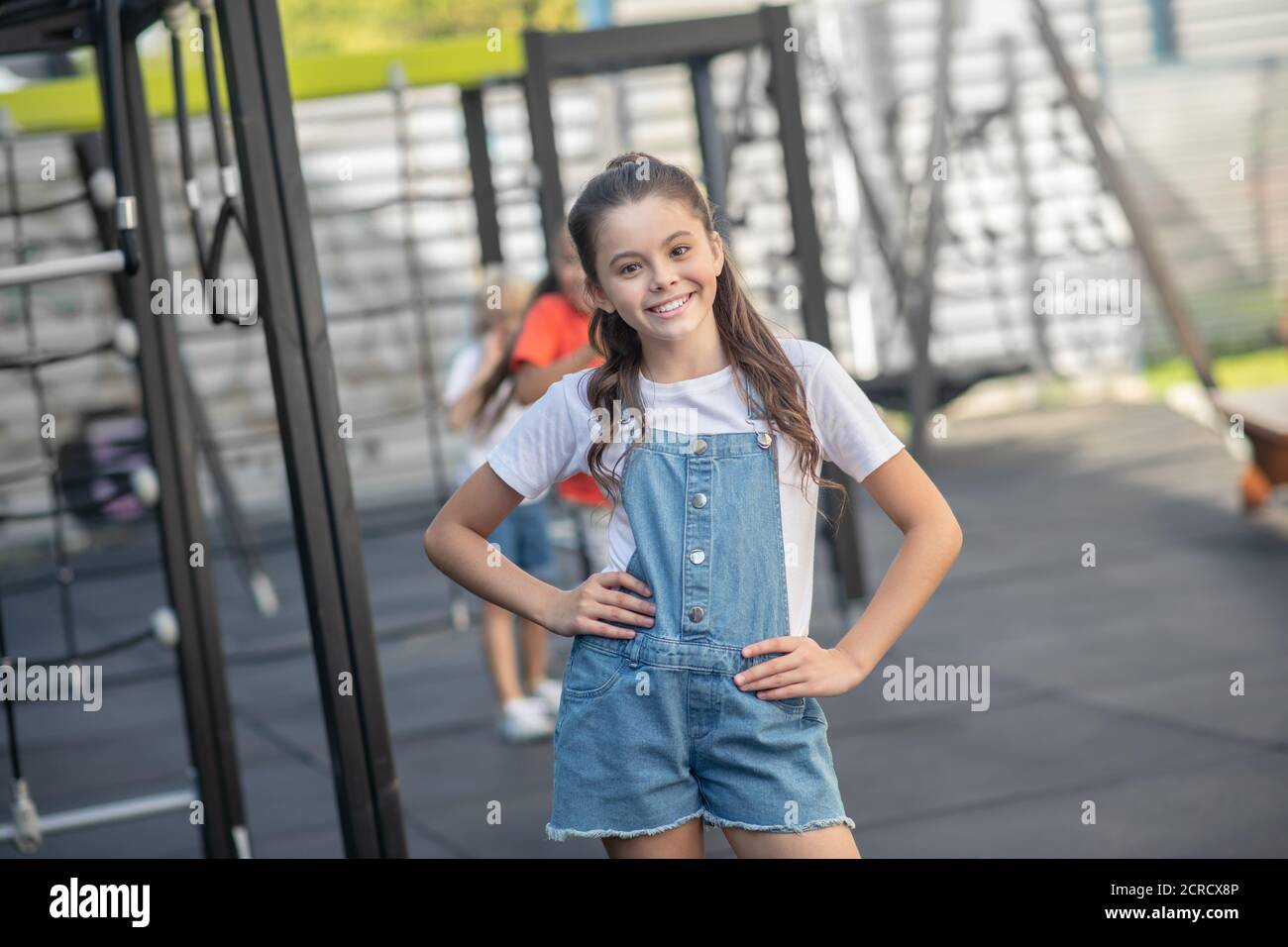 Mädchen in Denim stehen und lächeln glücklich Stockfoto