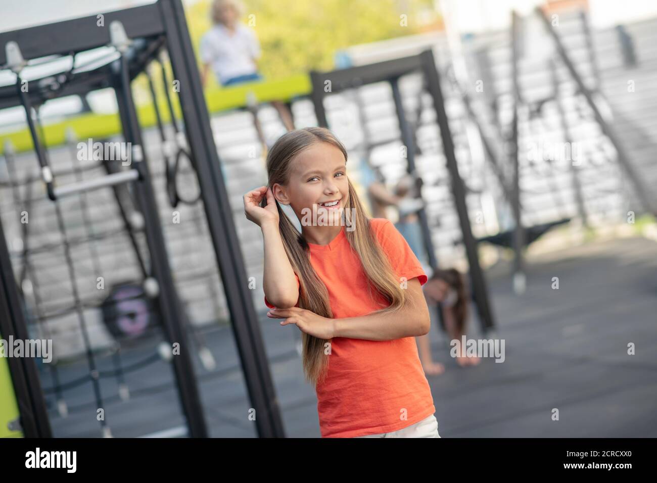 Nettes Mädchen in orange T-Shirt lächelnd schön und gut aussehend Stockfoto