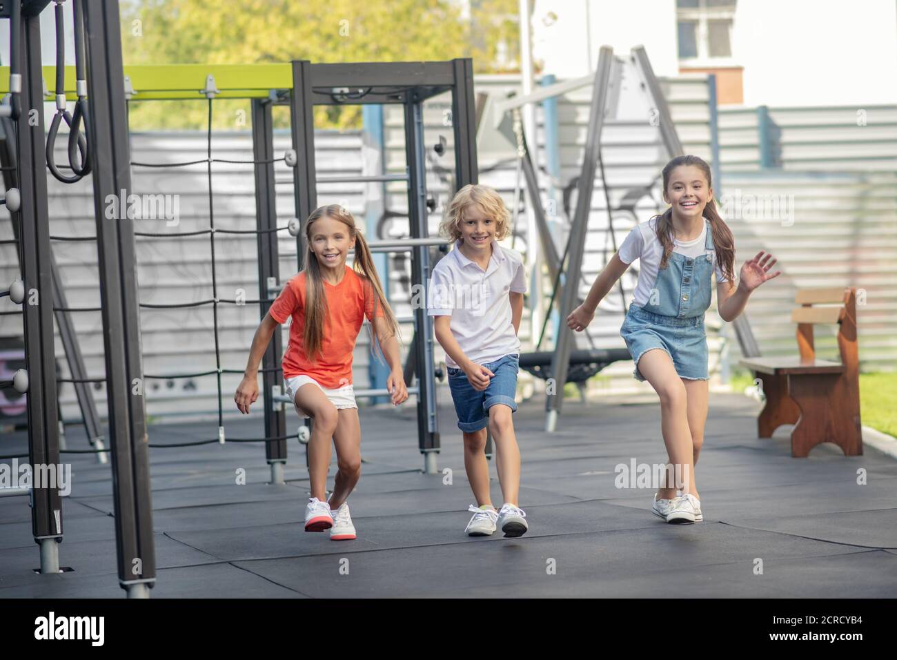 Drei Freunde laufen auf dem Spielplatz und fühlen sich glücklich Stockfoto
