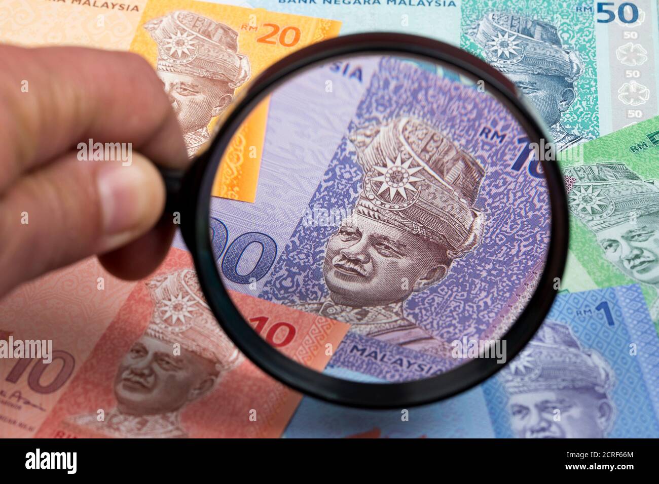 Malaysisches Geld in einer Lupe ein geschäftlicher Hintergrund Stockfoto