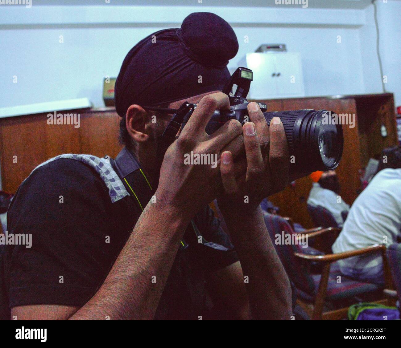 Ein Schüler mit nikon-Kamera im Klassenzimmer Porträt von anderen. Stockfoto