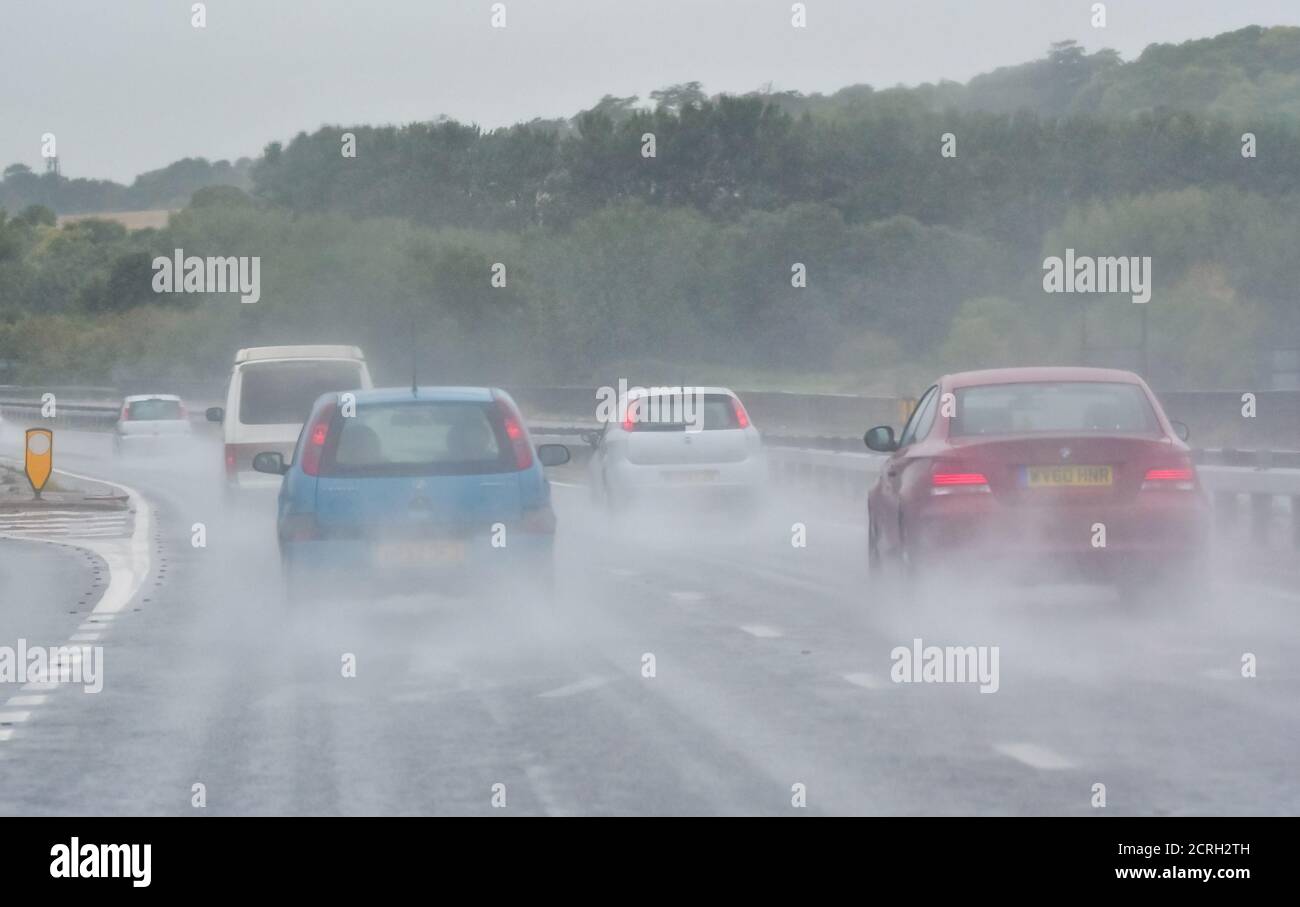 Fahrer, die Autos auf einer zweispurigen Fahrbahn bei starkem Regen mit schlechter Sicht in England, Großbritannien, fahren. Schlechtes Wetter und nasse, gefährliche Straße beim Regen. Stockfoto