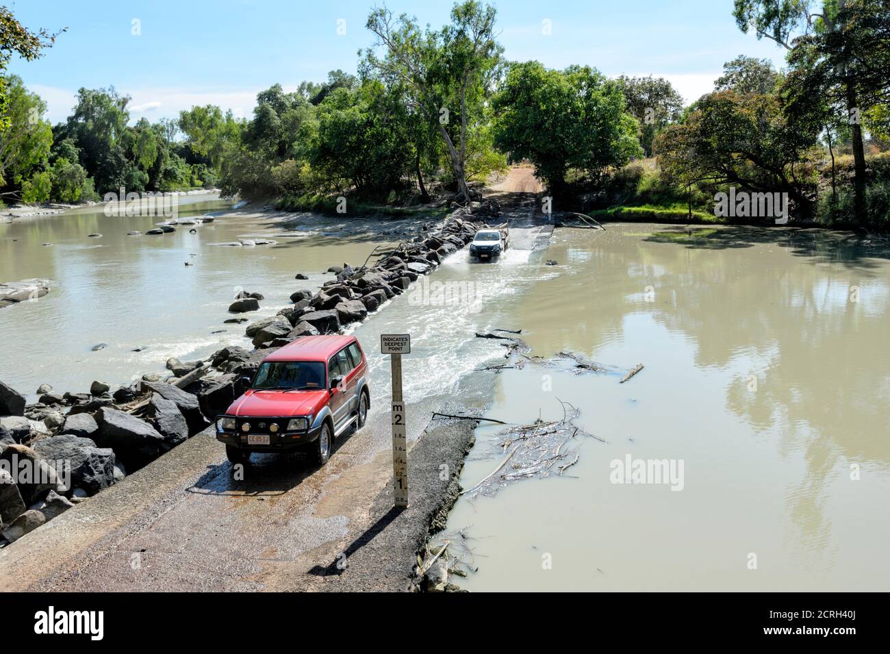 Fahrzeuge fahren durch die gefährliche Gezeitenüberquerung des East Alligator River an der berühmten Cahill's Crossing, Kakadu National Park, Northern Territor Stockfoto