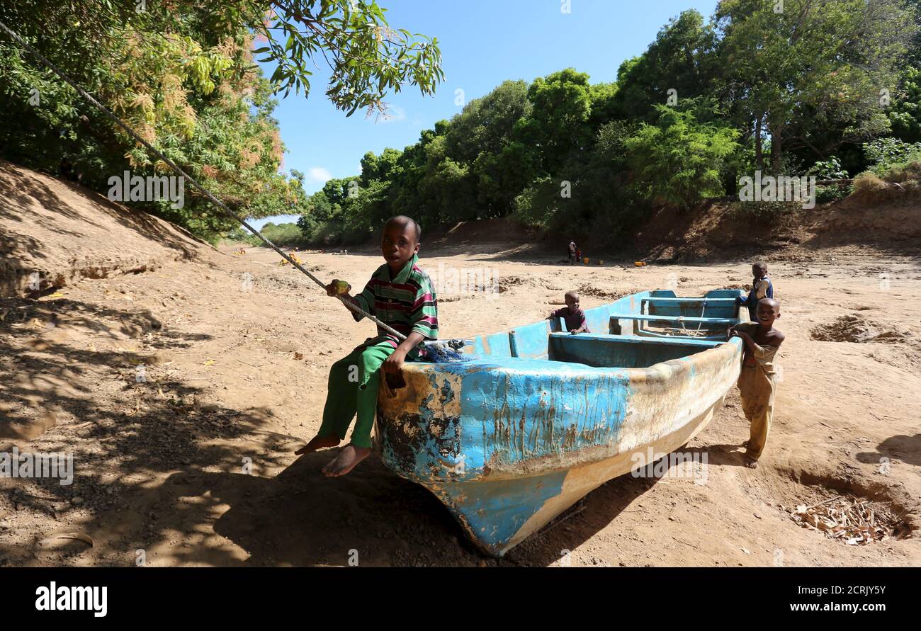 Kinder spielen auf einem verlassenen Boot entlang des Shabelle-Flussbettes, das aufgrund der Dürre in Somalias Shabelle-Region trocken ist, 19. März 2016. REUTERS/Feisal Omar Stockfoto
