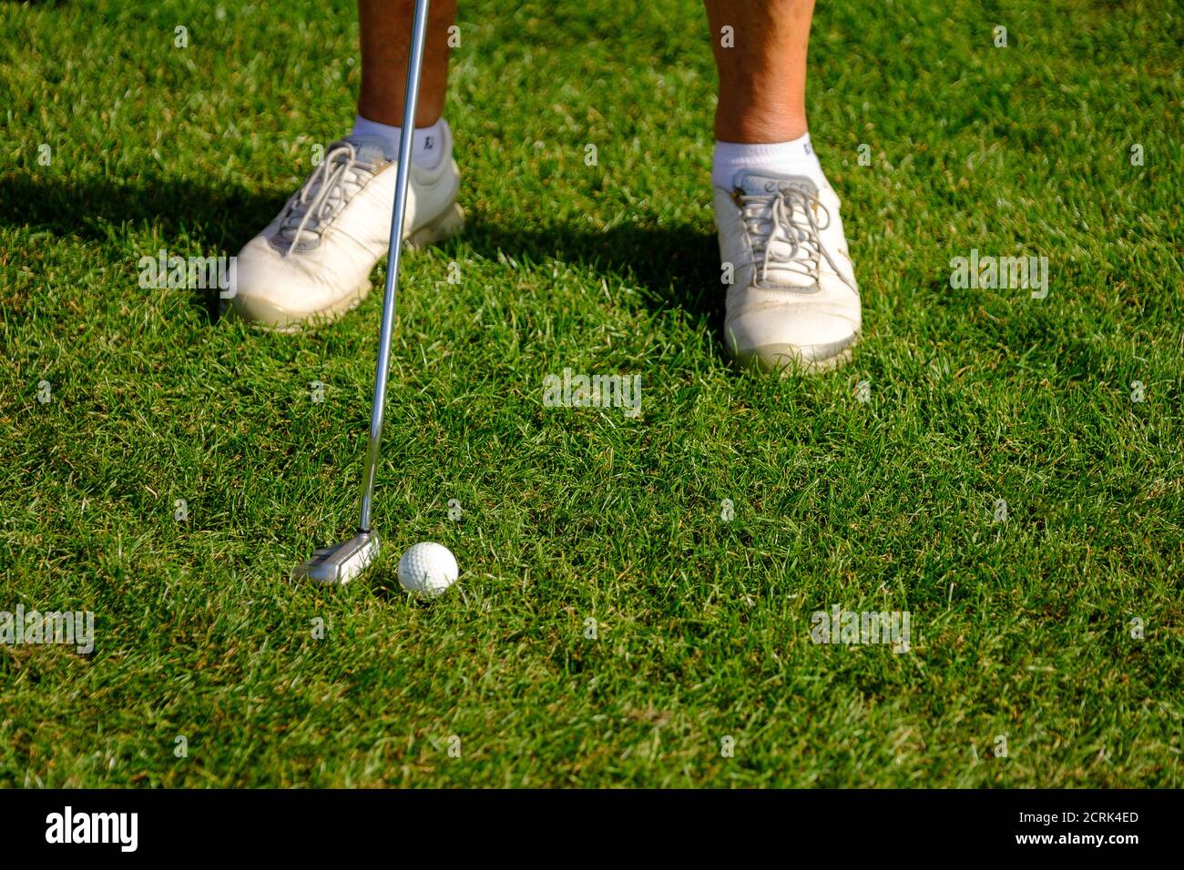 Füße der weiblichen Golfspielerin in weißen Schuhen, die Golf spielen Kurs Stockfoto