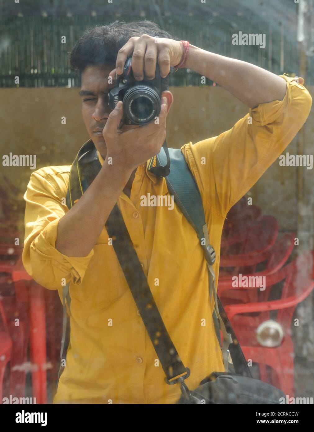 Ein indischer Junge klickt Bild von sich selbst durch Spiegel mit nikon-Kamera. Stockfoto
