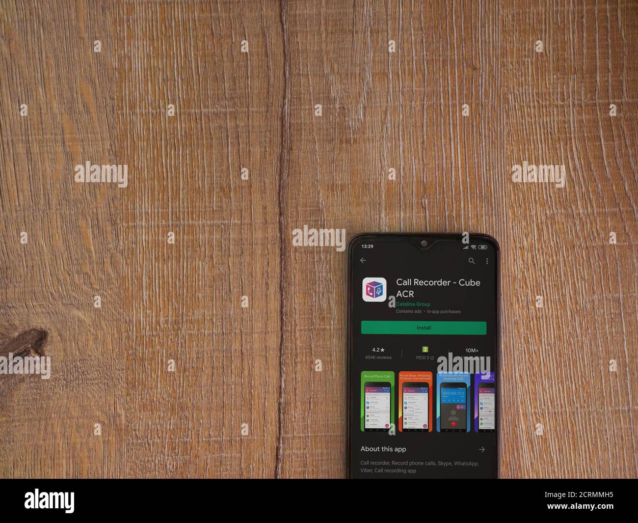 LOD, Israel - 8. Juli 2020: Cube ACR App Play Store Seite auf dem Display eines schwarzen Smartphone auf Holzhintergrund. Draufsicht flach liegend mit Kopie Stockfoto