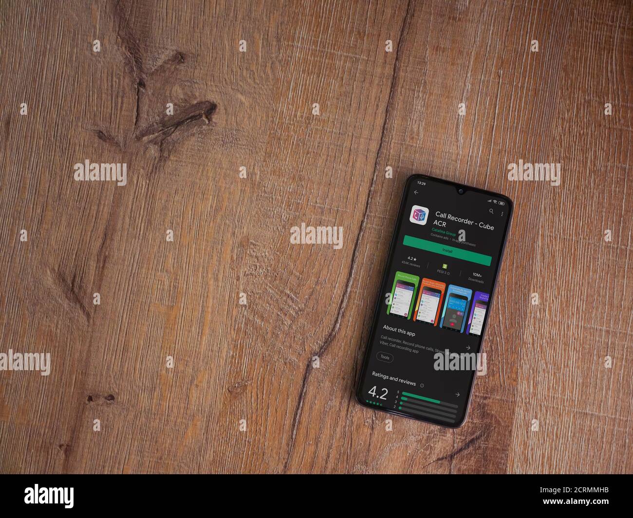 LOD, Israel - 8. Juli 2020: Cube ACR App Play Store Seite auf dem Display eines schwarzen Smartphone auf Holzhintergrund. Draufsicht flach liegend mit Kopie Stockfoto