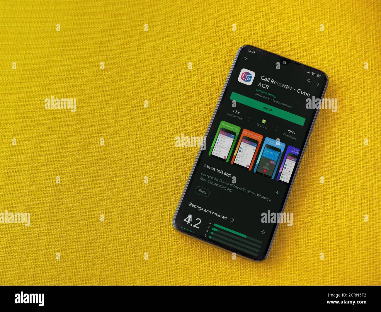 LOD, Israel - 8. Juli 2020: Cube ACR App Play Store Seite auf dem Display eines schwarzen Smartphone auf einem gelben Stoff Hintergrund. Draufsicht flach liegend Stockfoto
