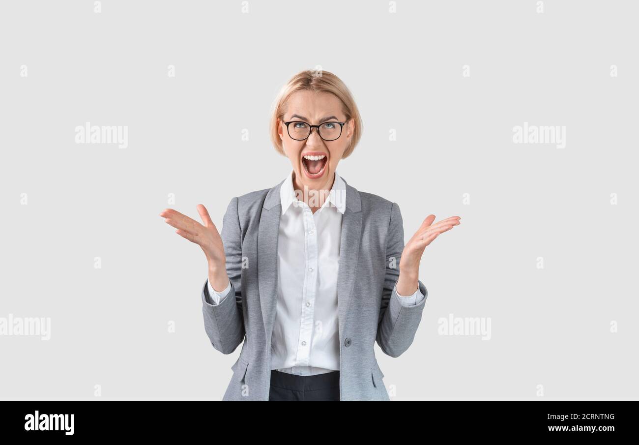 Attraktive Unternehmerin in formeller Kleidung schreiend in Wut auf hellem Hintergrund, Panorama Stockfoto