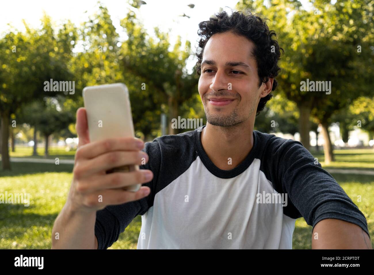 Porträt des jungen Mannes mit dem Handy in der parken Stockfoto
