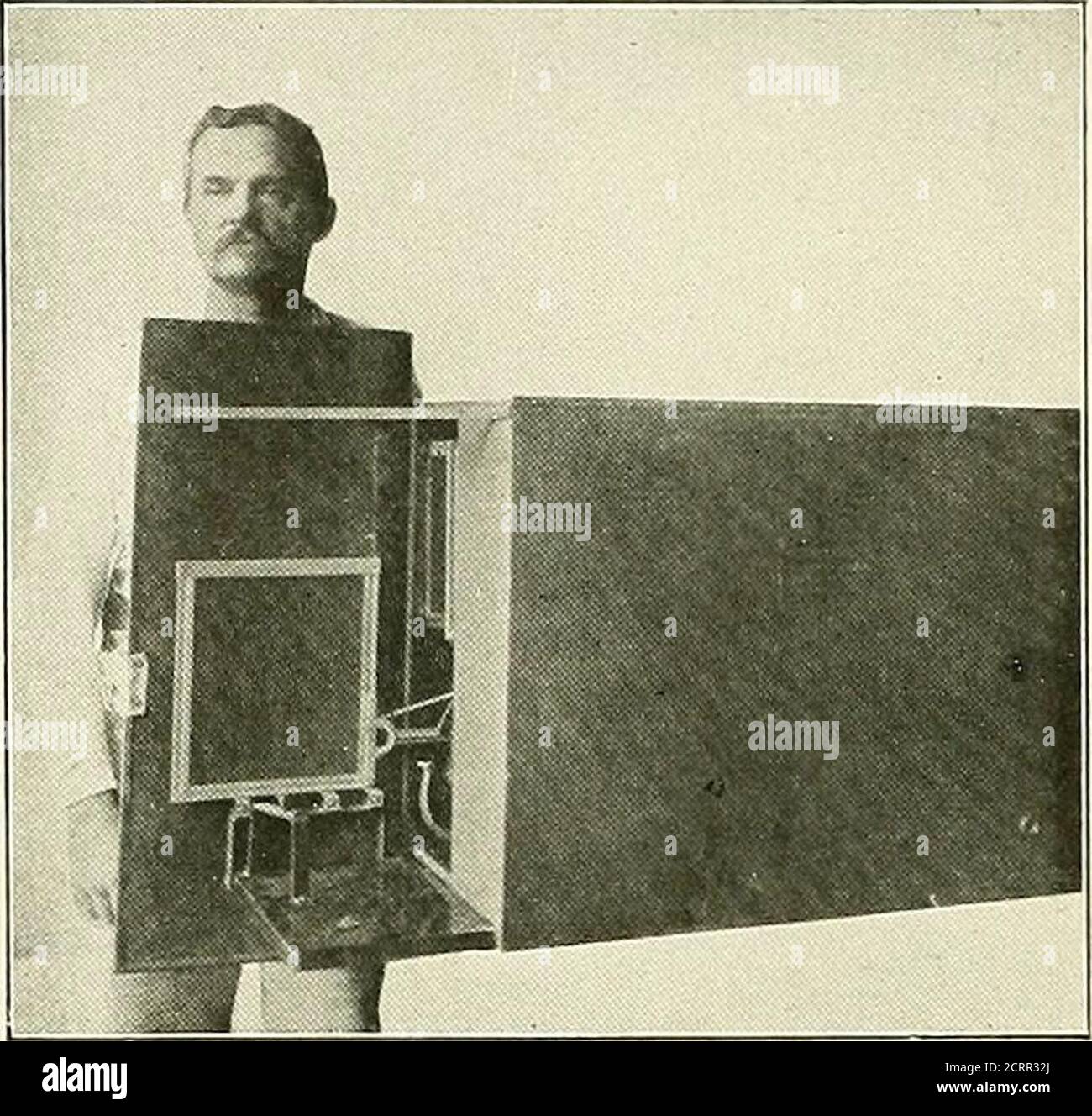. Die Grundsätze und Praxis der roentgenologischen Technik . Abb. i8i. – Rückseite der Platte, die die Pfanne hält. Der Stift ist gemacht, um auf einer -- Spur zu bewegen, dies bringt die verschiedenen Viertel der Platte unter dem Loch in den Tisch für die Belichtung. (Hirsch.) Schatten auf zwei Metern, ist über einem Zentimeter, die Verzerrung in der letzteren Entfernung ist vernachlässigbar. Bei Thoraxuntersuchungen ist eine dorso-ventrale Exposition gewöhnlich mit dem Ziel der Bestimmung der Herzgröße verbunden.die Röhre ist auf den sechsten dorsalen ver-tebra fokussiert. Es ist von Vorteil, Bleimarker in der suprasternalen Kerbe oder am zi-phus zu platzieren. Es ist nicht n Stockfoto