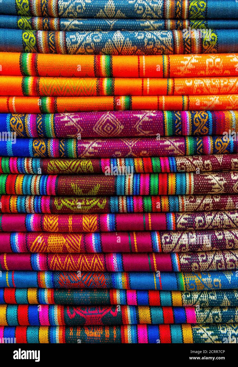 Ein Stapel von bunten traditionellen Textilien in den Anden sonntagsmarkt in Otavalo, nördlich von Quito, Ecuador. Stockfoto