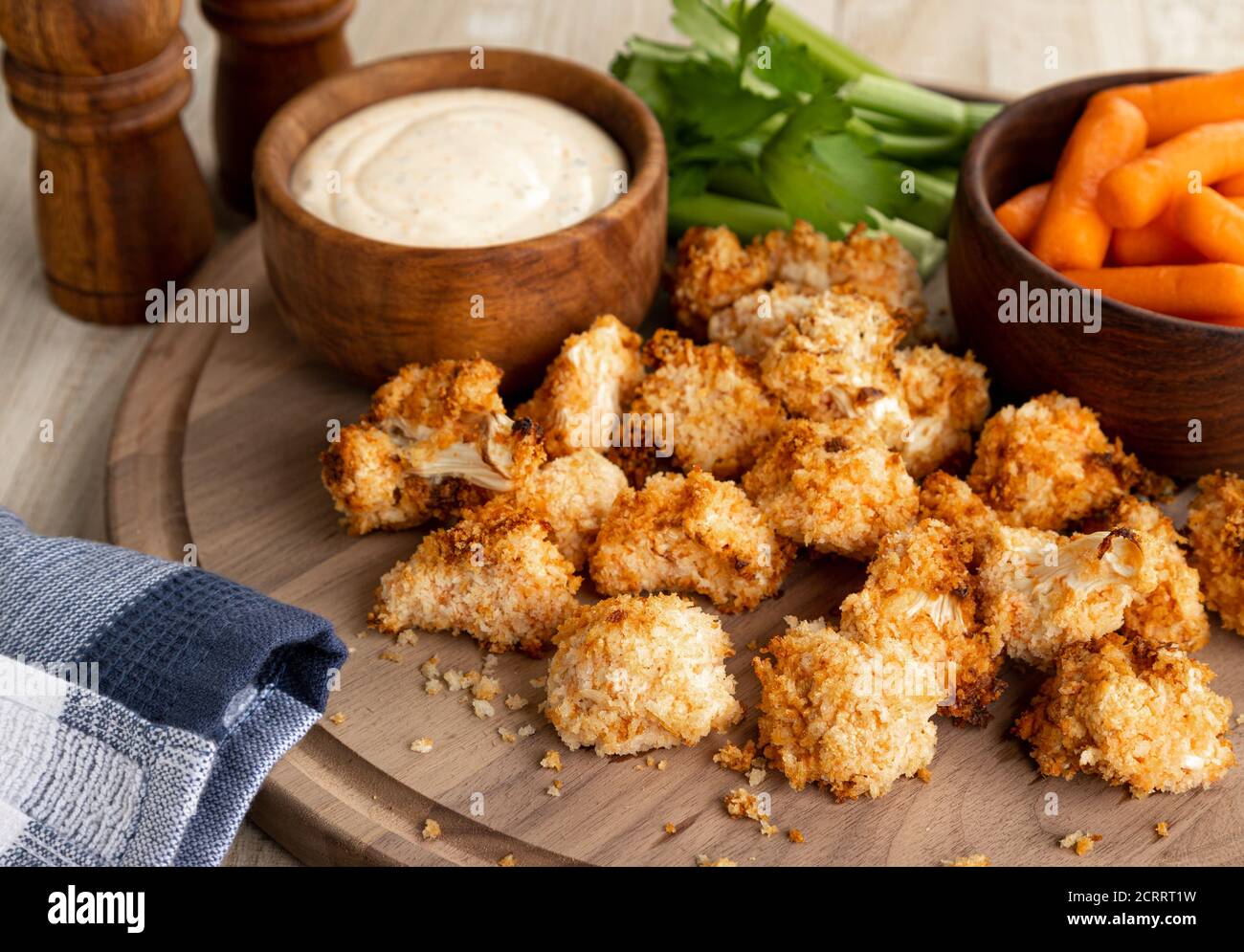 Knusprige, luftgebratene Blumenkohlröschen und Ranchdip mit Karotten Und Sellerie auf einem Holztablett Stockfoto