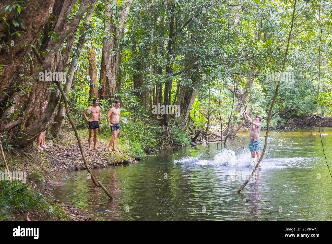 Northern Territory, Australien - 18. März 2020: Jugendliche tummeln sich in einem schattigen Bach und laufen durch einen Regenwald im nördlichen Gebiet von aus Stockfoto