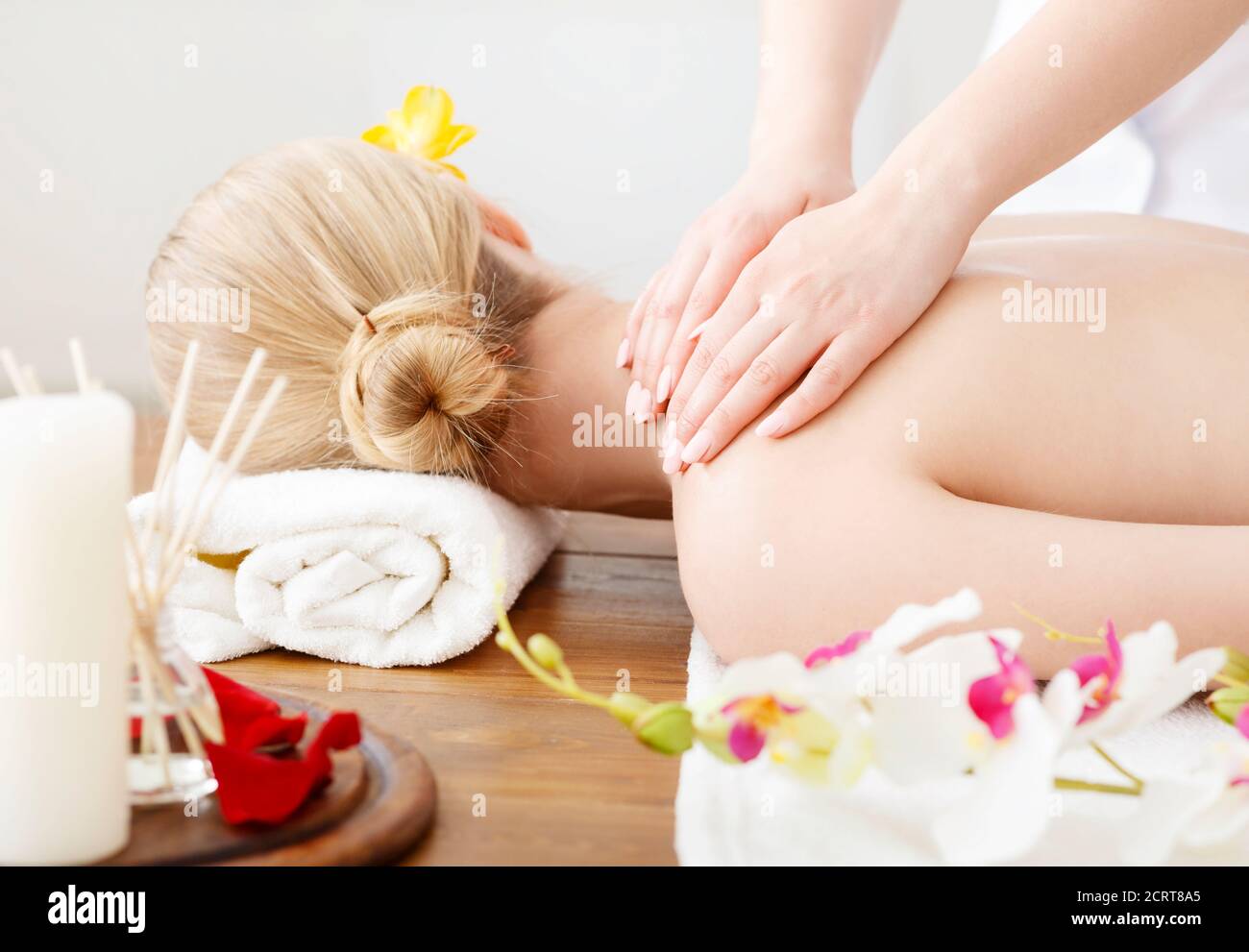 Weibliche Hände massieren auf weiblichen Schultern, liegend auf dem Tisch Stockfoto