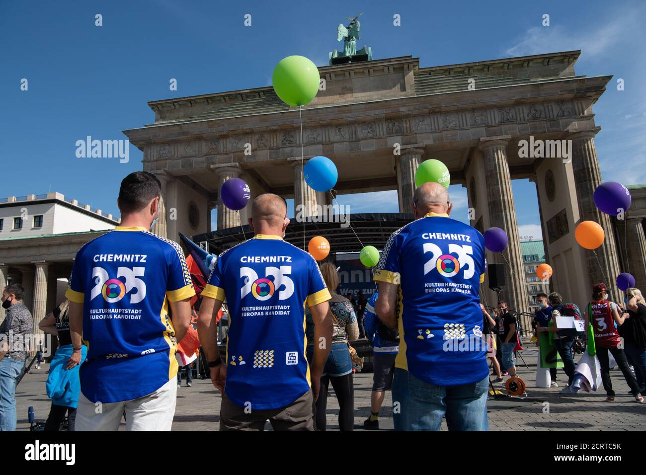 Berlin, Deutschland. September 2020. Die Teilnehmer einer Veranstaltung der Chemnitzer Kulturschaffenden stehen mit Ballons am Brandenburger Tor in T-Shirts mit der Aufschrift "Chemnitz 2025 Kulturhauptstadt. Europäischer Kandidat“. In ungewöhnlicher Weise hat Chemnitz das sogenannte BID Book für die Bewerbung als Kulturhauptstadt Europas 2025 eingereicht. Das 60-seitige Dokument ist am Sonntagnachmittag - nach einer 48-stündigen Tour durch mehrere Bundesländer - mit dem Fahrrad am Brandenburger Tor in Berlin angekommen. Quelle: Paul Zinken/dpa/Alamy Live News Stockfoto