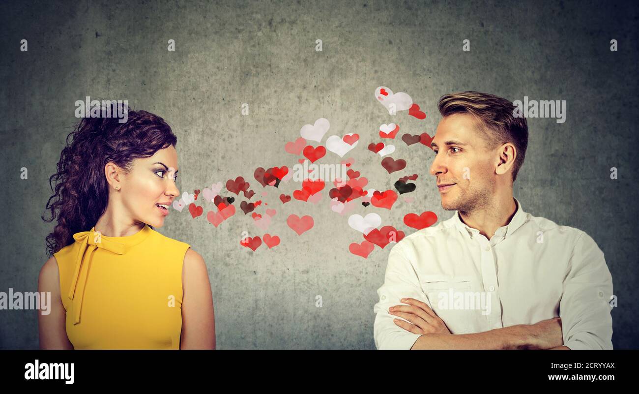 Schöne junge Frau in der Liebe sendet Herzen Küsse zu einem Schöner Mann Stockfoto