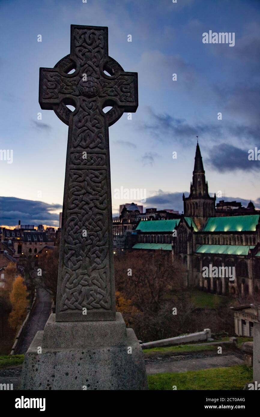 Glasgow / Schottland - 13. Nov 2013: Glasgow Necropolis. Fallen Sie in die Stadt. Grabmal mit keltischem Kreuz. Glasgow Cathedral verschwommen im Hintergrund. Stockfoto
