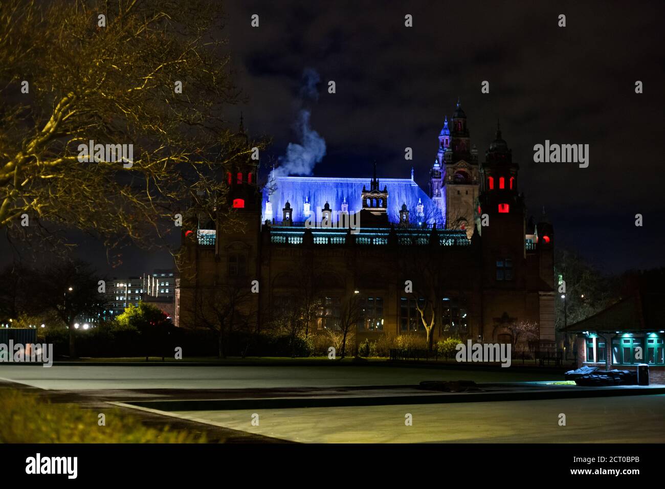 Glasgow, Schottland im Herbst. Kelvingrove Kunstgalerie und Museum bei Nacht. Farbbeleuchtung des Gebäudes. Schwarzer Nachthimmel. Stockfoto