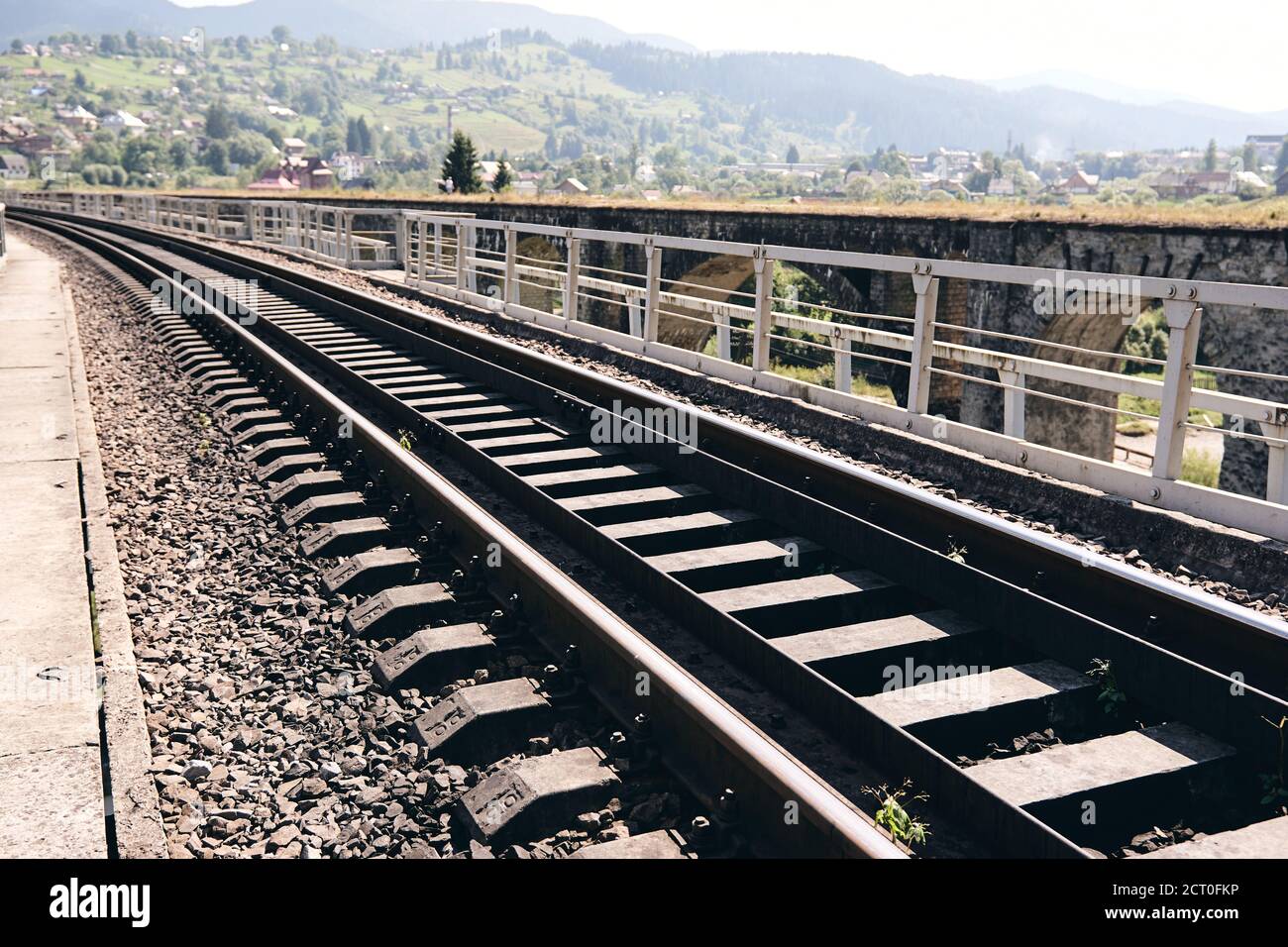 Bahnschienen in der Landschaft. Eisenbahnschienen bei Sonnenuntergang. Lokales Reisekonzept Stockfoto