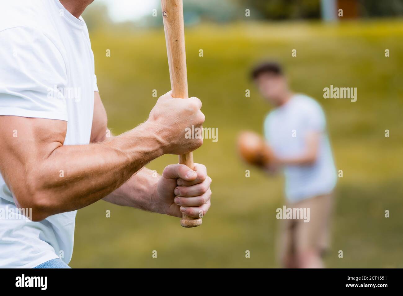 Beschnittene Ansicht des Mannes hält Softball Fledermaus in der Nähe Teenager Junge Stockfoto
