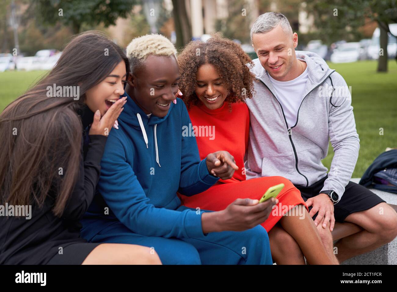 Multi ethnische Freunde im Freien suchen Smartphone-Bildschirm. Diverse Gruppe Menschen Afro american asiatisch kaukasisch verbringen Zeit zusammen multirassischen männlichen Fem Stockfoto