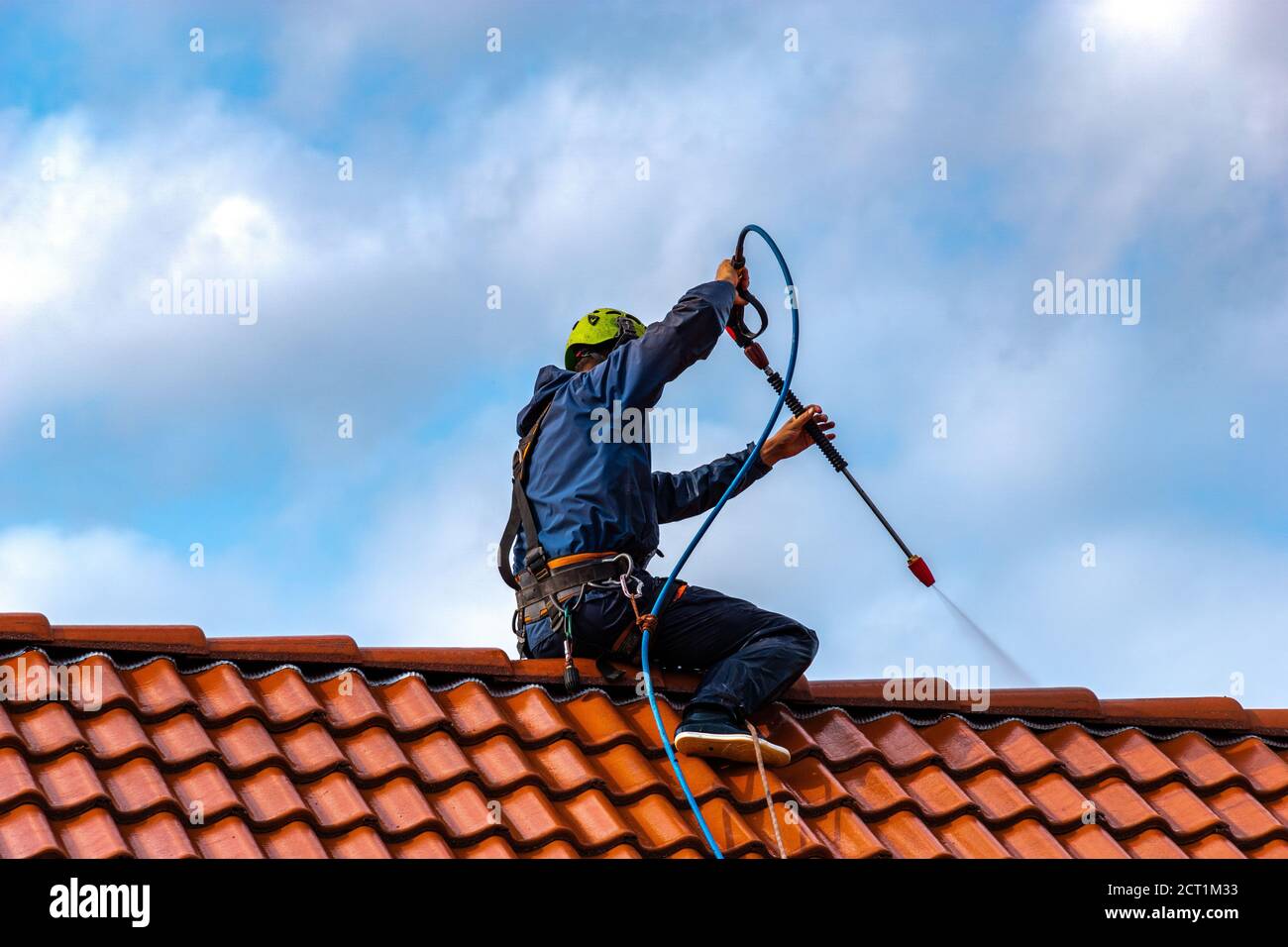 Arbeiter, die das Dach mit Druckwasser waschen Stockfoto