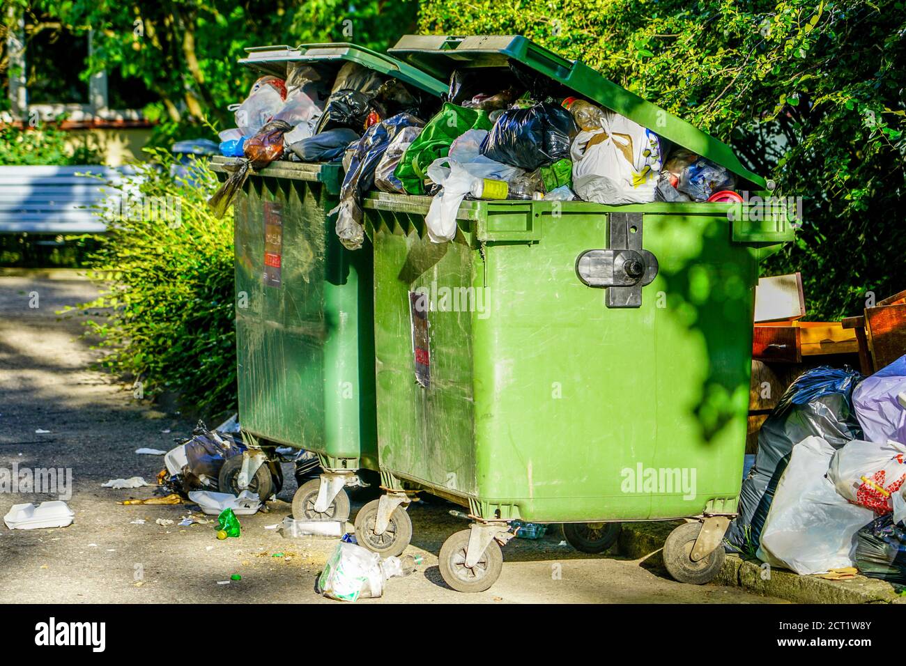 Überfüllte grüne Plastikmüllbehälter in der Stadt Stockfoto