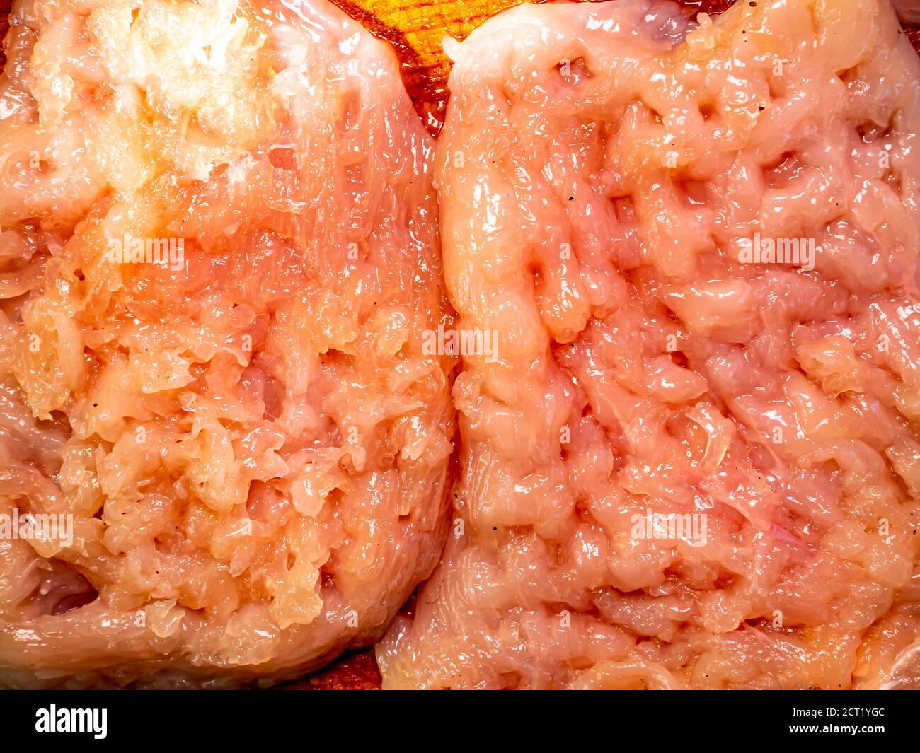 Rohes Fleisch hacken auf einem Schneidebrett. Küchenwerkzeug. Der Prozess der Zubereitung eines Fleischstückes. Wohnküche. Rezept. Speisekarte. Hintergrundbild. Stockfoto