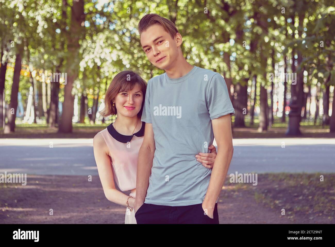 Lächelndes Paar hat ein Date im öffentlichen Park. Junge kaukasische Liebhaber treffen sich im Sommer im Freien. Stockfoto