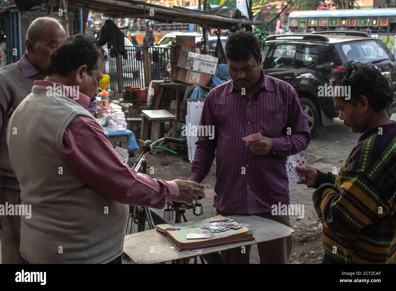 Kolkata, Indien - 1. Februar 2020: Vier nicht identifizierte Männer in bunten Hemden spielen am 1. Dezember 2020 in Kolkata, Indien, Karten in den örtlichen Straßen Stockfoto