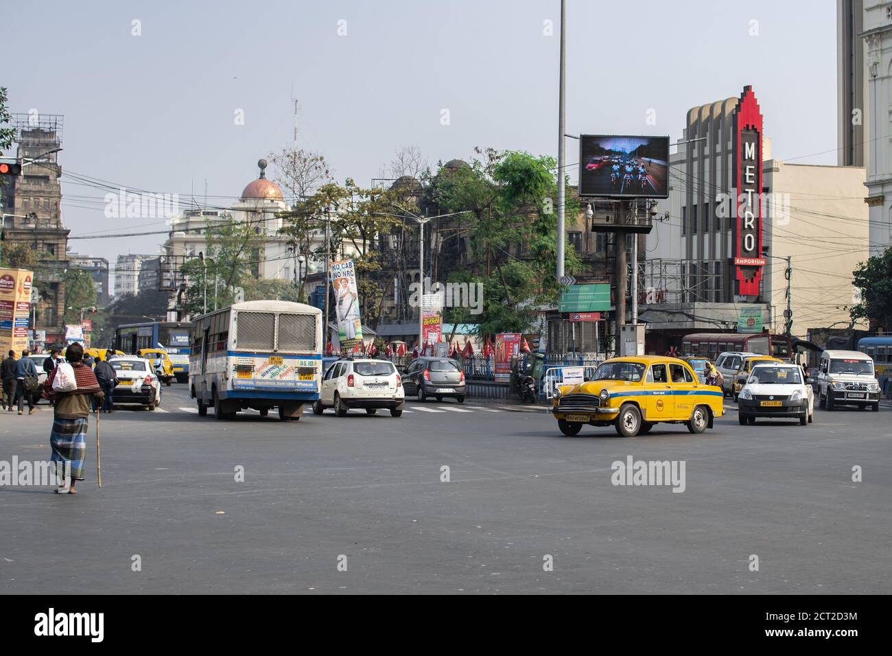 Kolkata, Indien - 1. Februar 2020: Unbekannte Menschen gehen auf der Straße, während Busse und Autos im Verkehr am 1. Februar 2020 in Kolkata vorbeifahren Stockfoto