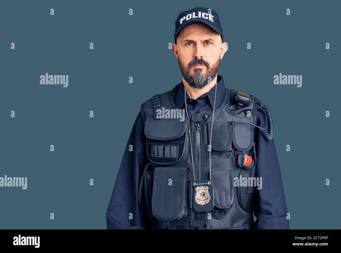 Junge gutaussehende Mann trägt Polizei Uniform entspannt mit ernsten Ausdruck im Gesicht. Einfach und natürlich Blick auf die Kamera. Stockfoto