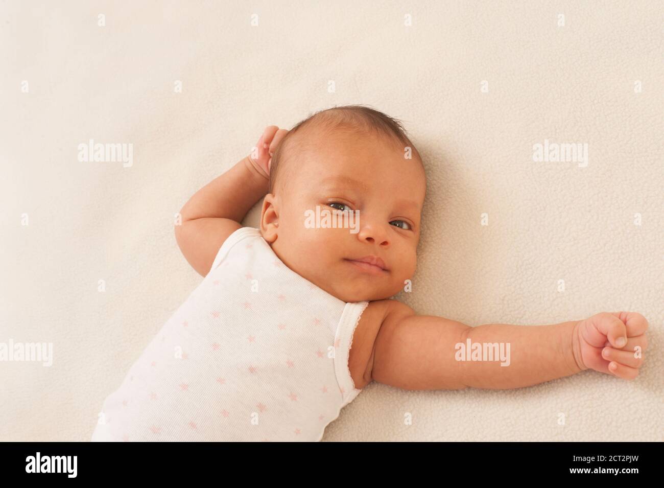 Säuglingsentwicklung 6 Wochen altes neugeborenes Mädchen auf dem Rücken liegend Neugeborenes Reflex: Tonic Hals (Fechten) Stockfoto